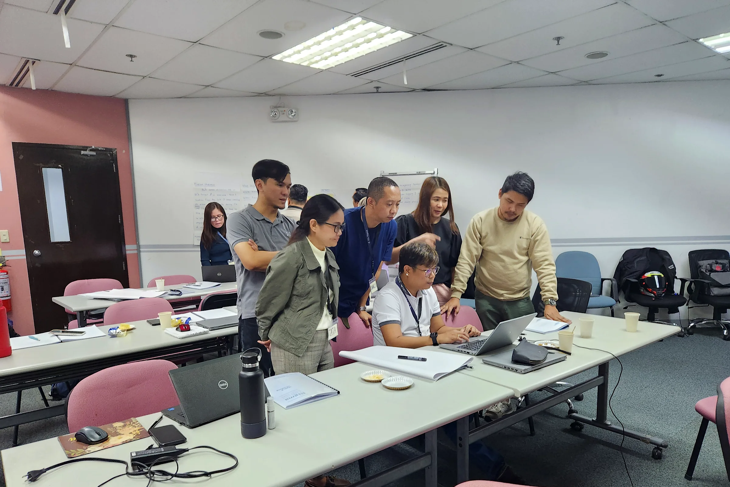 A small group gathered around a table, reviewing worksheets together during an exercise